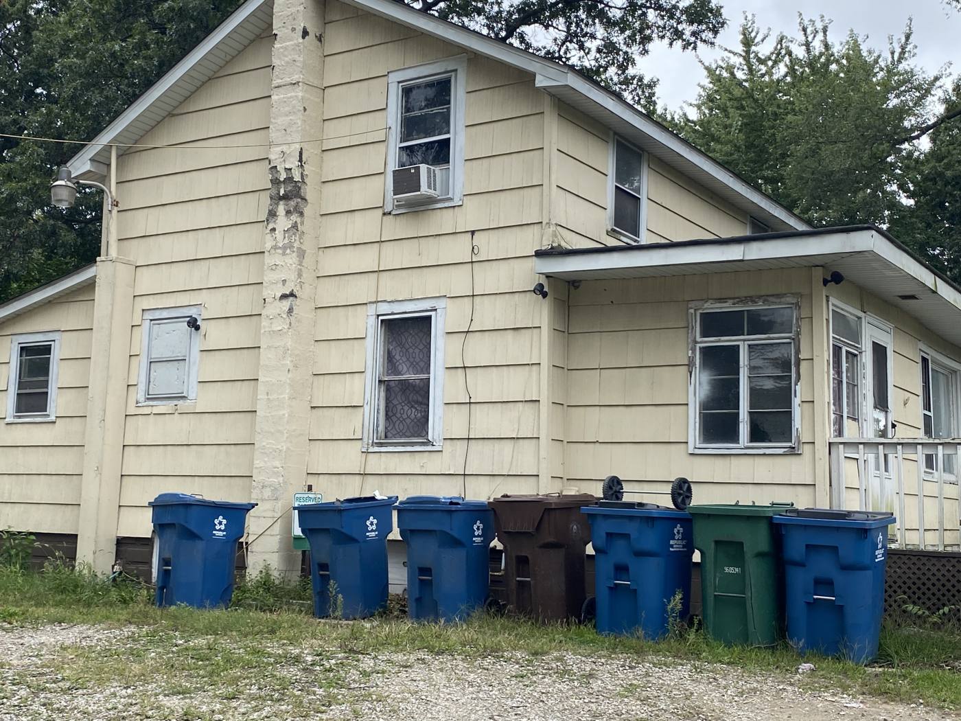 Older two-story home with weathered paint purchased as-is